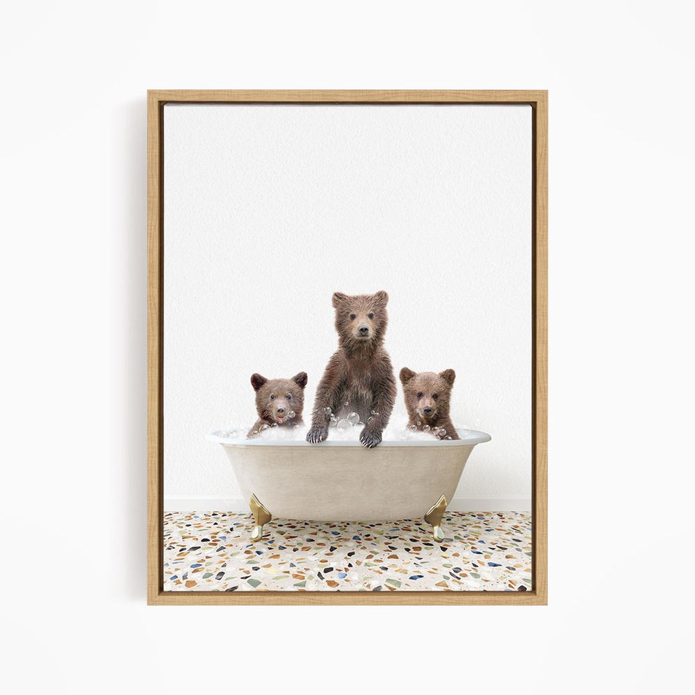 A framed image depicting three brown bears sitting in a white bathtub, with one bear sitting in the center and the other two bears sitting on either side.