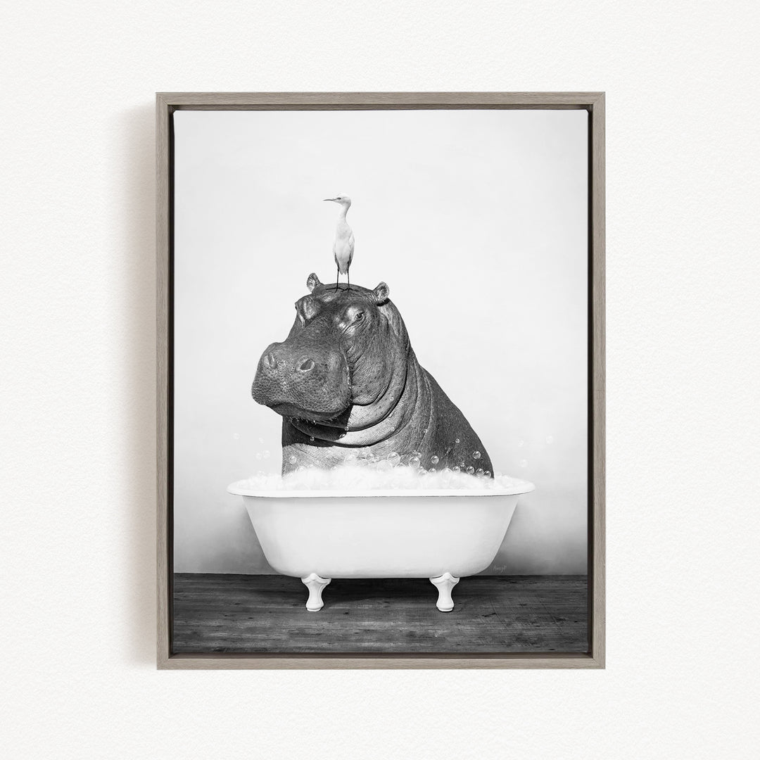 A black and white image of a hippopotamus sitting in a bathtub, with a bird perched on its head.