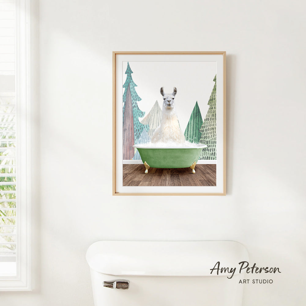 A framed print of a white llama sitting in a green bathtub, surrounded by trees, is hanging on a white wall.