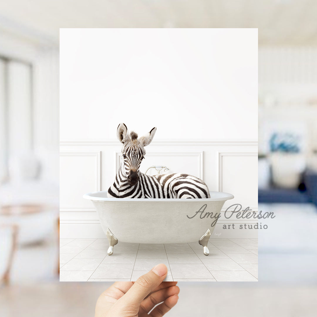 a hand holding a card with a zebra in a bathtub