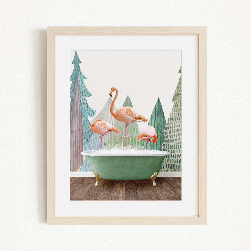 A framed image depicting three pink flamingos standing on a green bathtub, with a forest-like background.
