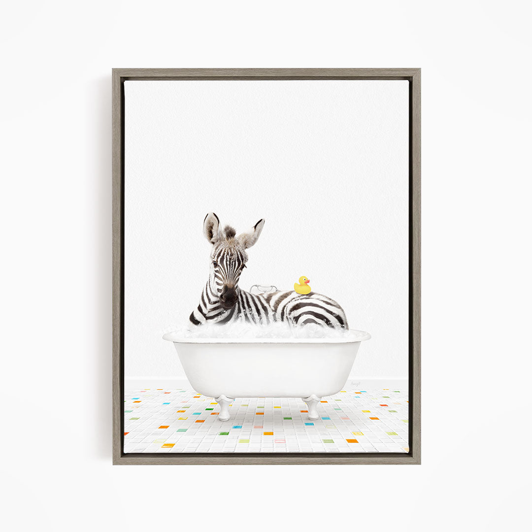 A zebra is sitting in a white bathtub, surrounded by a yellow rubber duck.