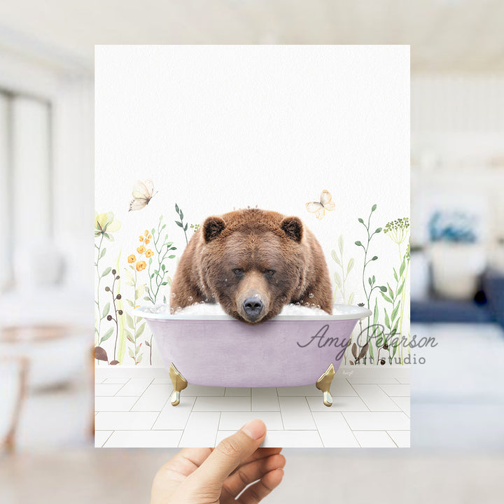 a hand holding a card with a bear in a bathtub