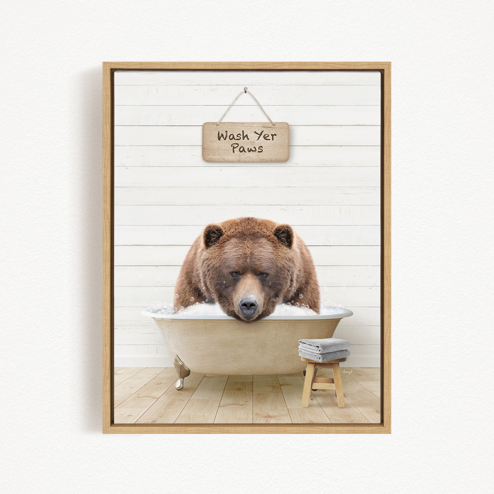 A brown bear is sitting in a bathtub filled with water, with a sign above it that says "Wash Your Paws".