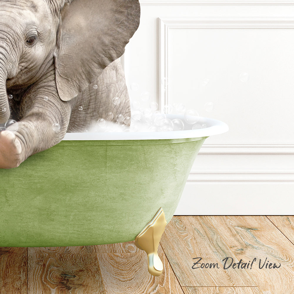A baby elephant sitting in a green bathtub filled with bubbles, with a wooden floor and a white wall in the background.