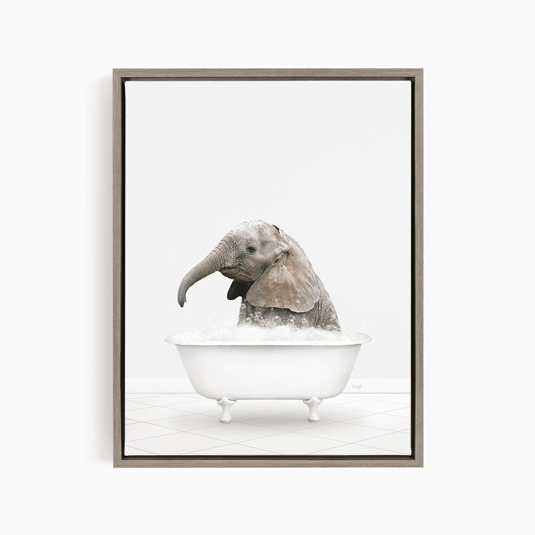 A baby elephant sitting in a white bathtub filled with water, appearing to enjoy the bath.
