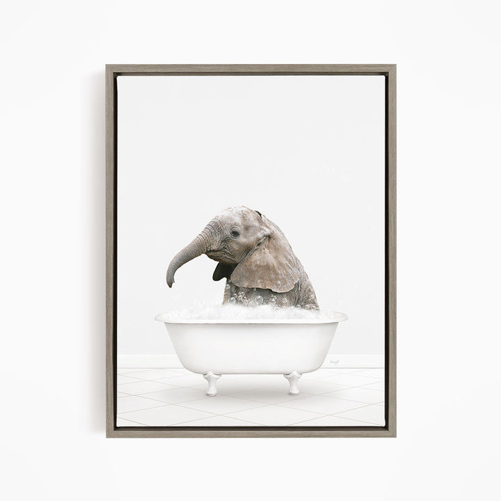 A baby elephant sitting in a white bathtub filled with water, appearing to enjoy the bath.