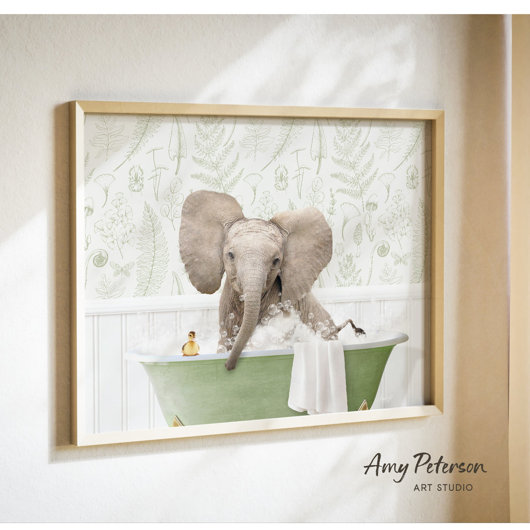 A framed image of an elephant sitting in a green bathtub, surrounded by bubbles and a yellow toy.