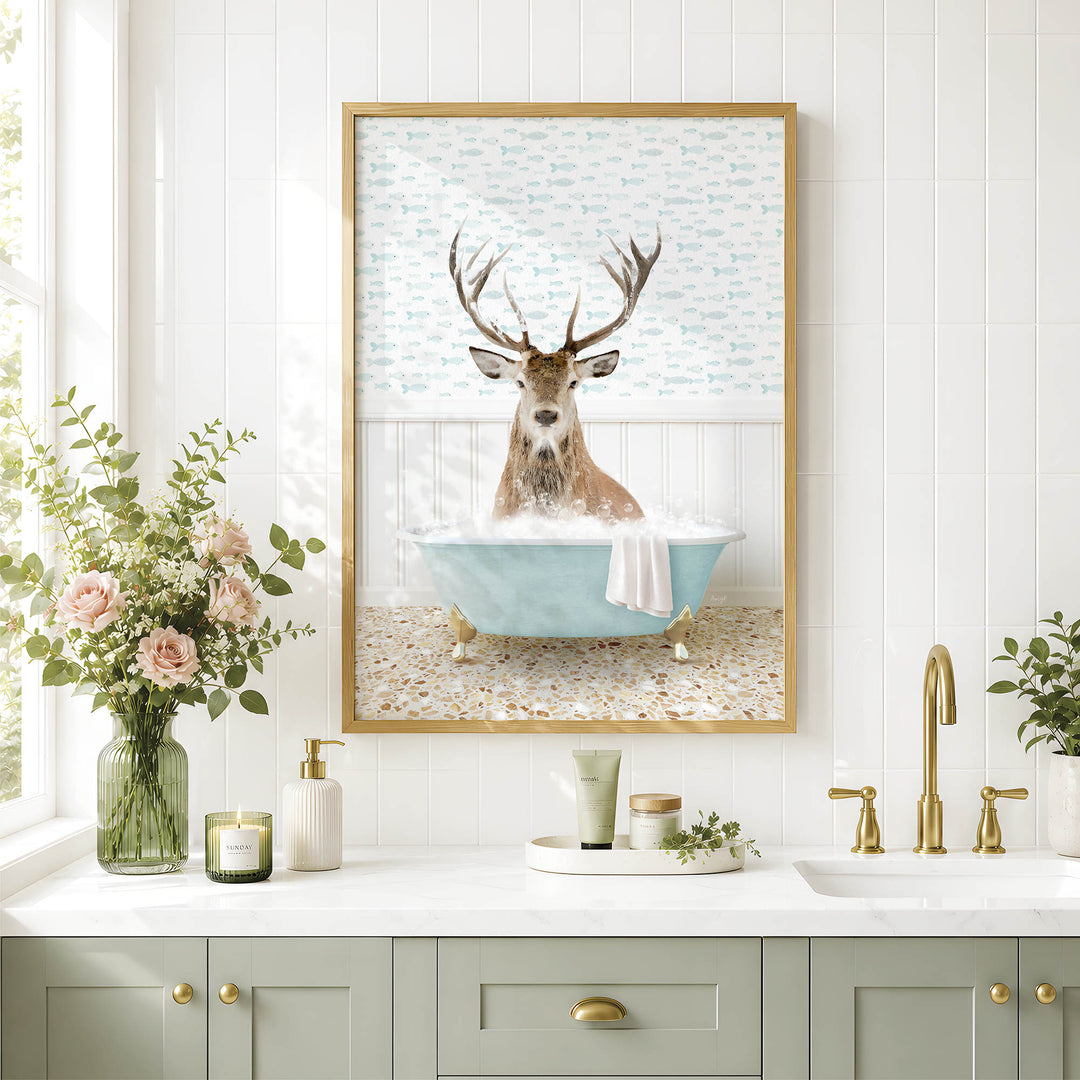 a bathroom scene with a framed picture of a deer sitting in a bathtub, surrounded by flowers and a green vase.