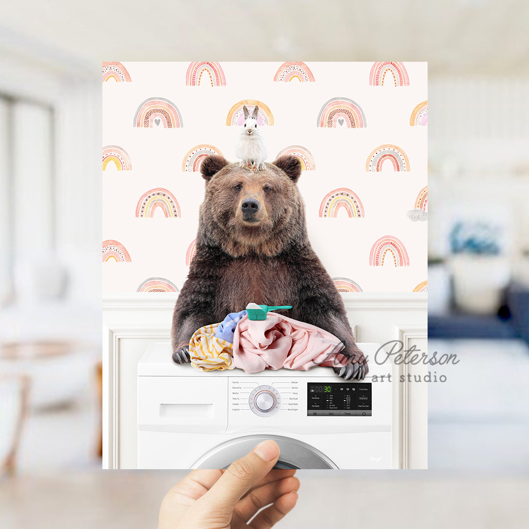 a brown bear sitting on top of a dryer