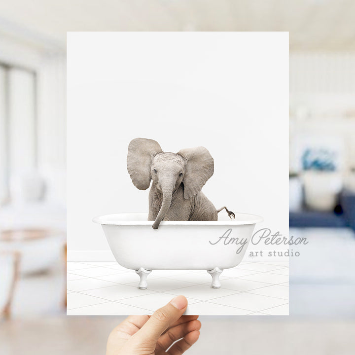 a person holding up a card with an elephant in a bathtub