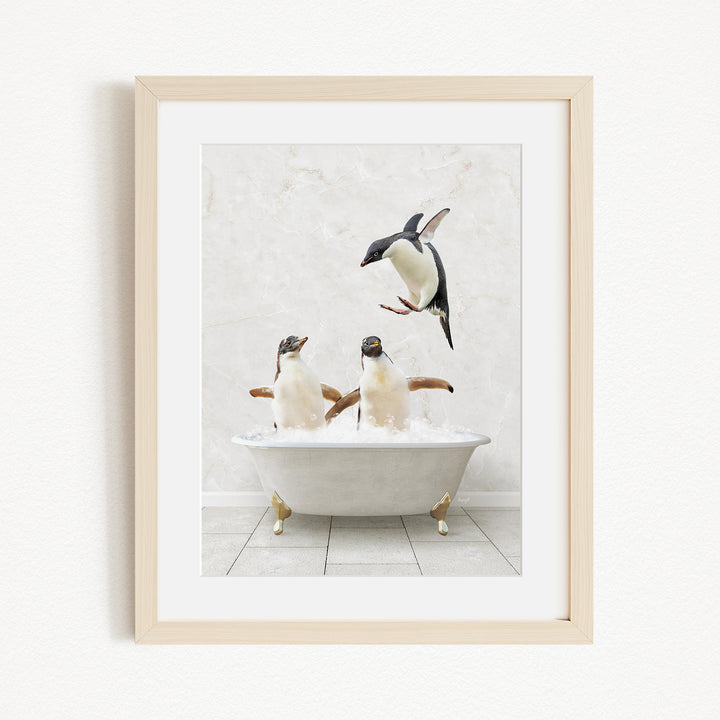 A framed image depicting two penguins sitting in a bathtub, with one penguin flying towards the other.