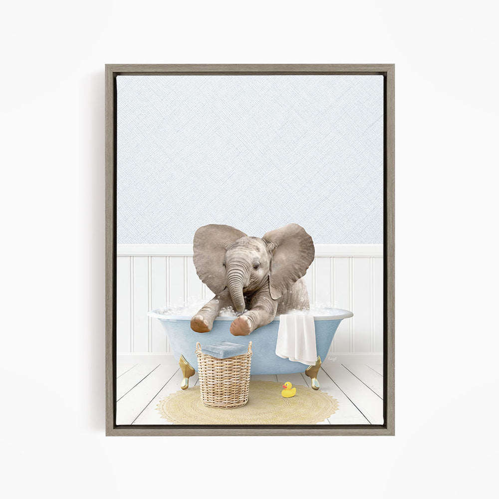 A baby elephant sitting in a bathtub filled with water, surrounded by a basket of toys and a yellow rubber ducky.