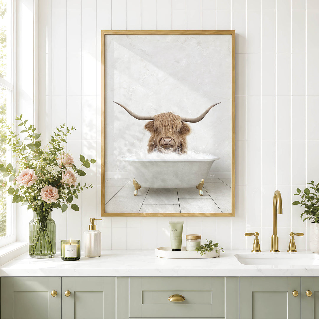 a bathroom with a framed picture of a Highland cow taking a bath in a tub, surrounded by various bathroom accessories and decor.