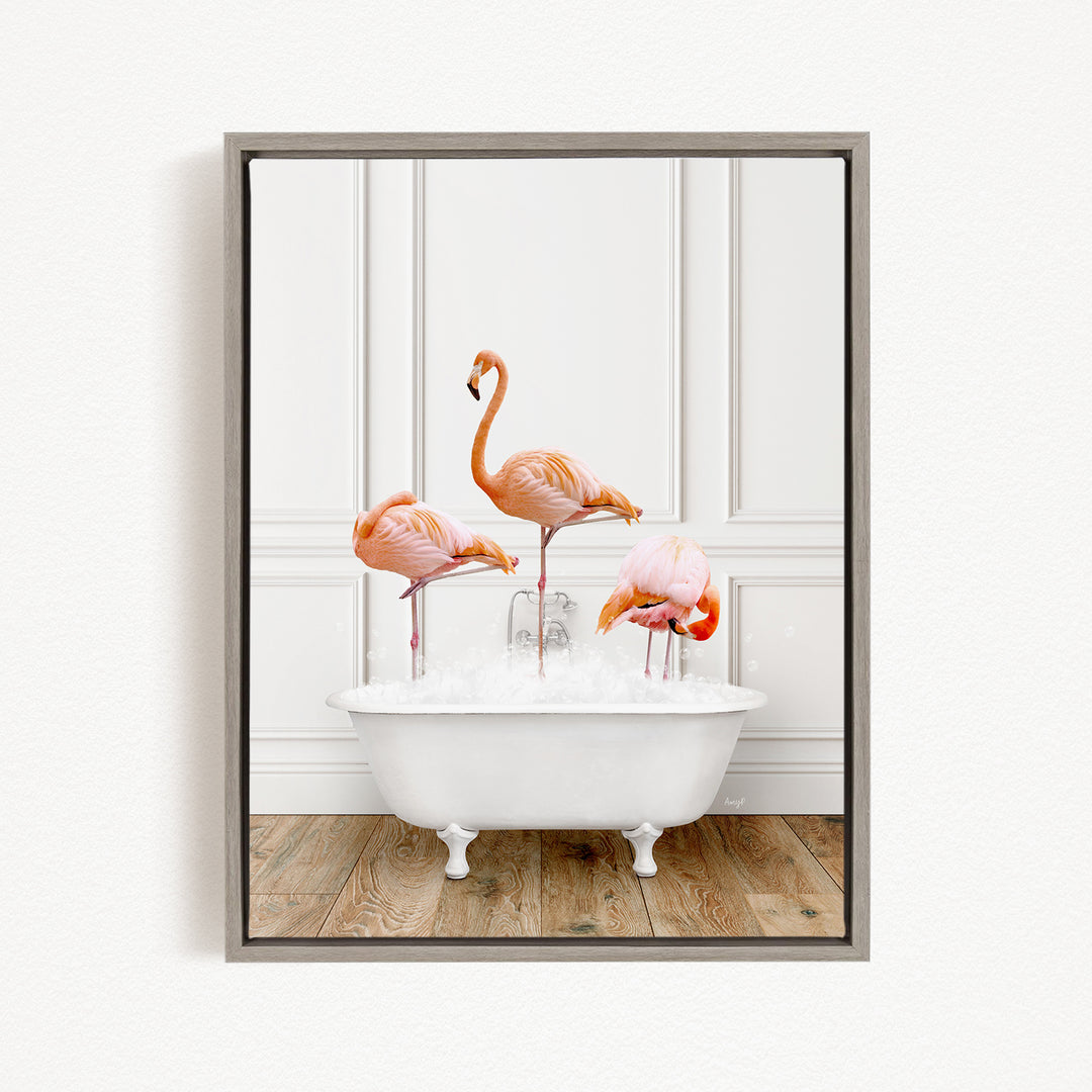 A framed image of three flamingos standing in a white bathtub filled with water.