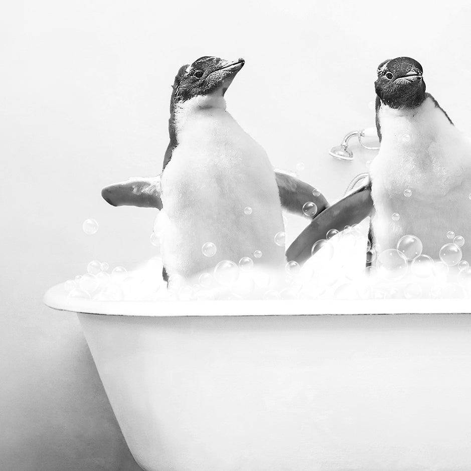 two penguins sitting in a bathtub with bubbles