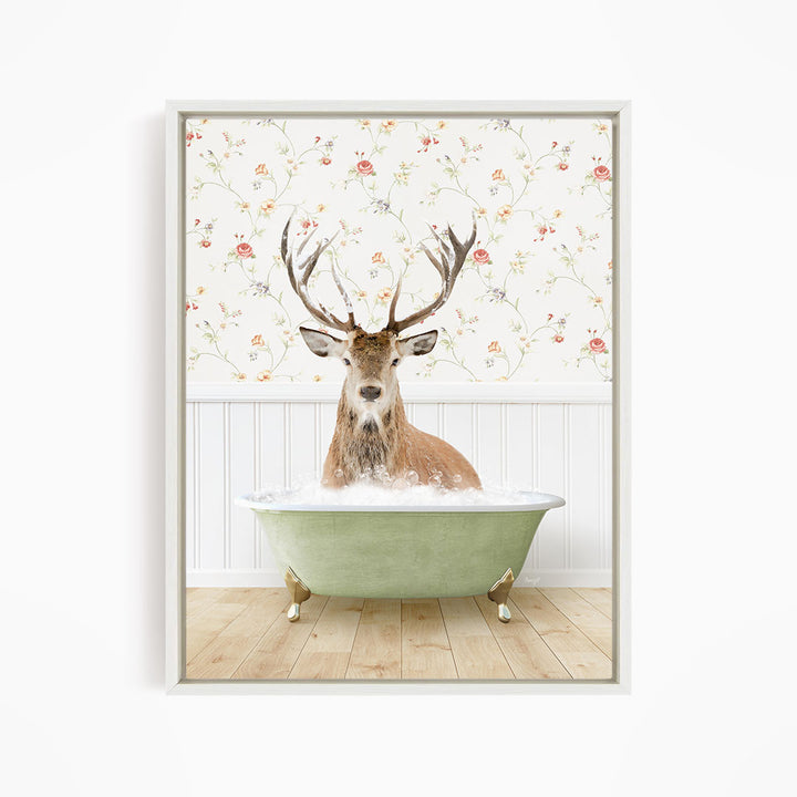 A deer with large antlers is sitting in a green bathtub filled with water, surrounded by a floral wallpaper.
