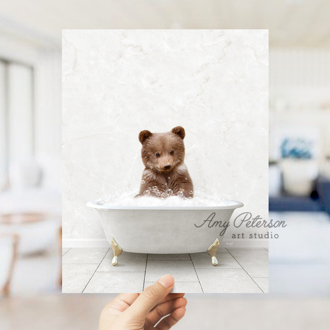 a hand holding up a polaroid picture of a teddy bear in a bathtub