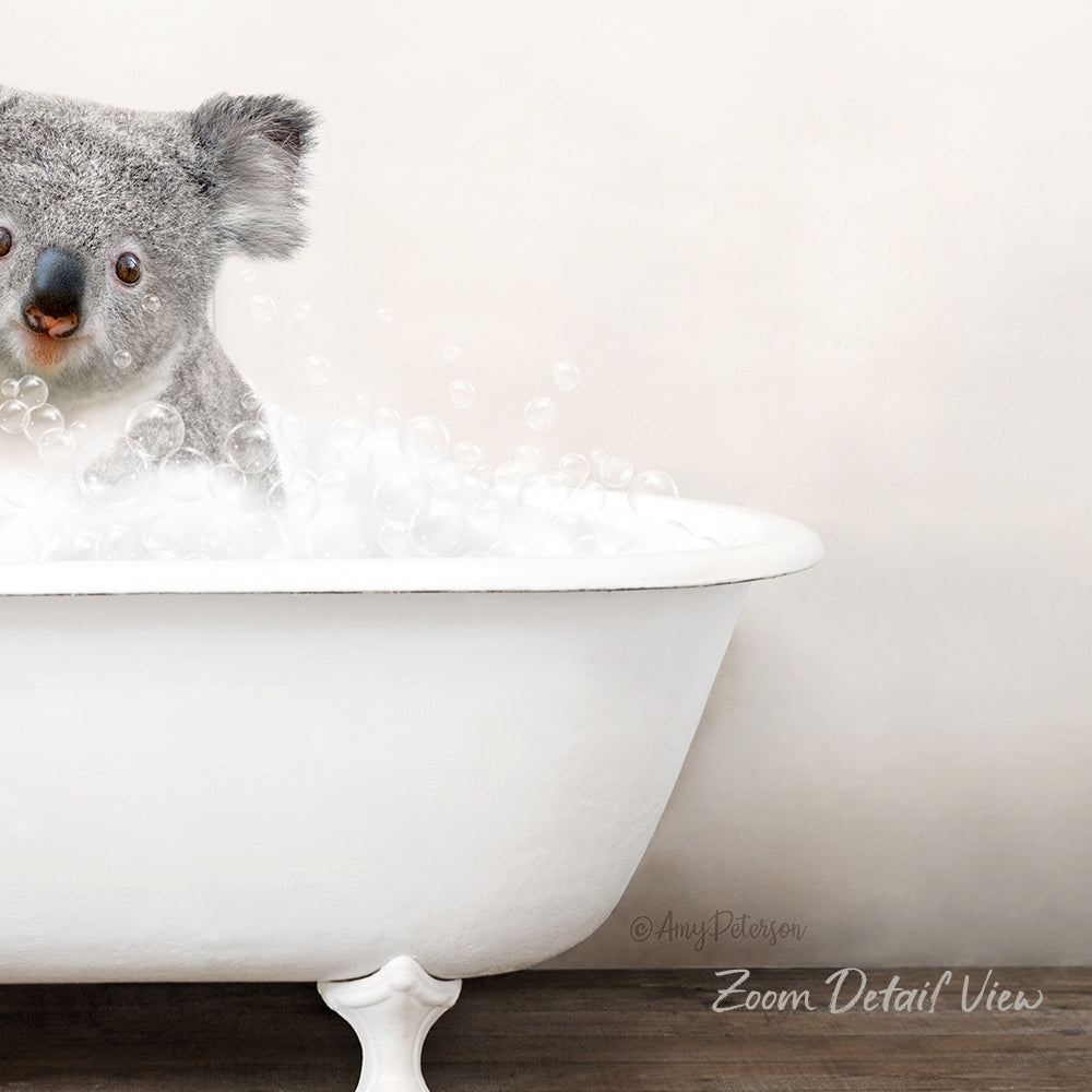 A koala is sitting in a white bathtub filled with bubbles, creating a playful and whimsical scene.
