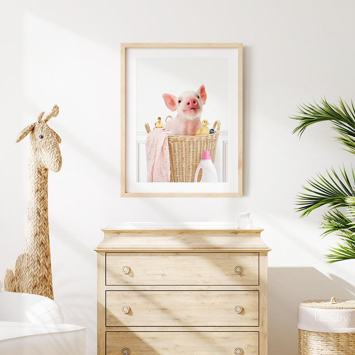 a picture of a pig in a basket on a wall above a dresser