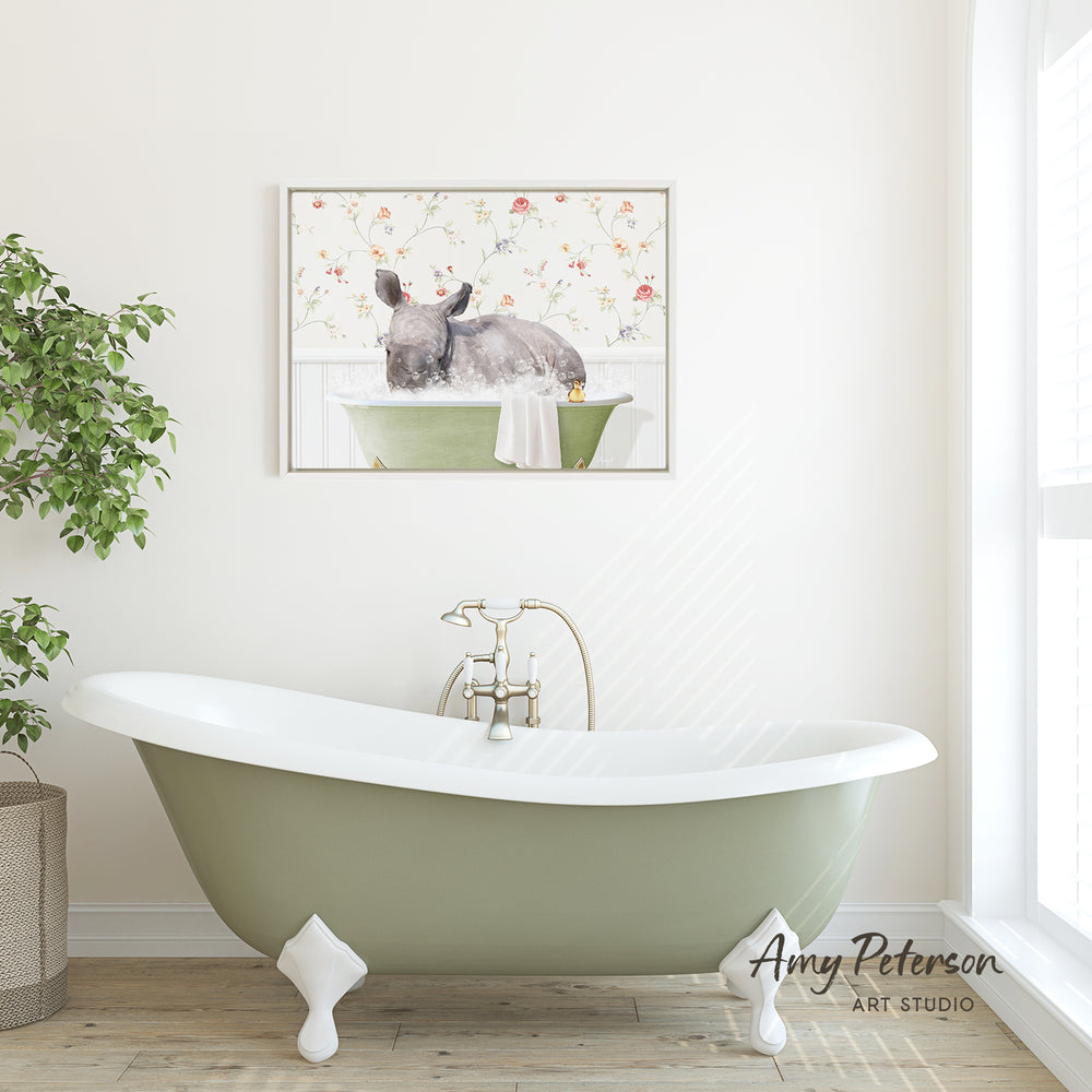 A green clawfoot bathtub with a white interior sits in a bright, airy bathroom, accompanied by a framed painting of a rhinoceros in a bathtub.
