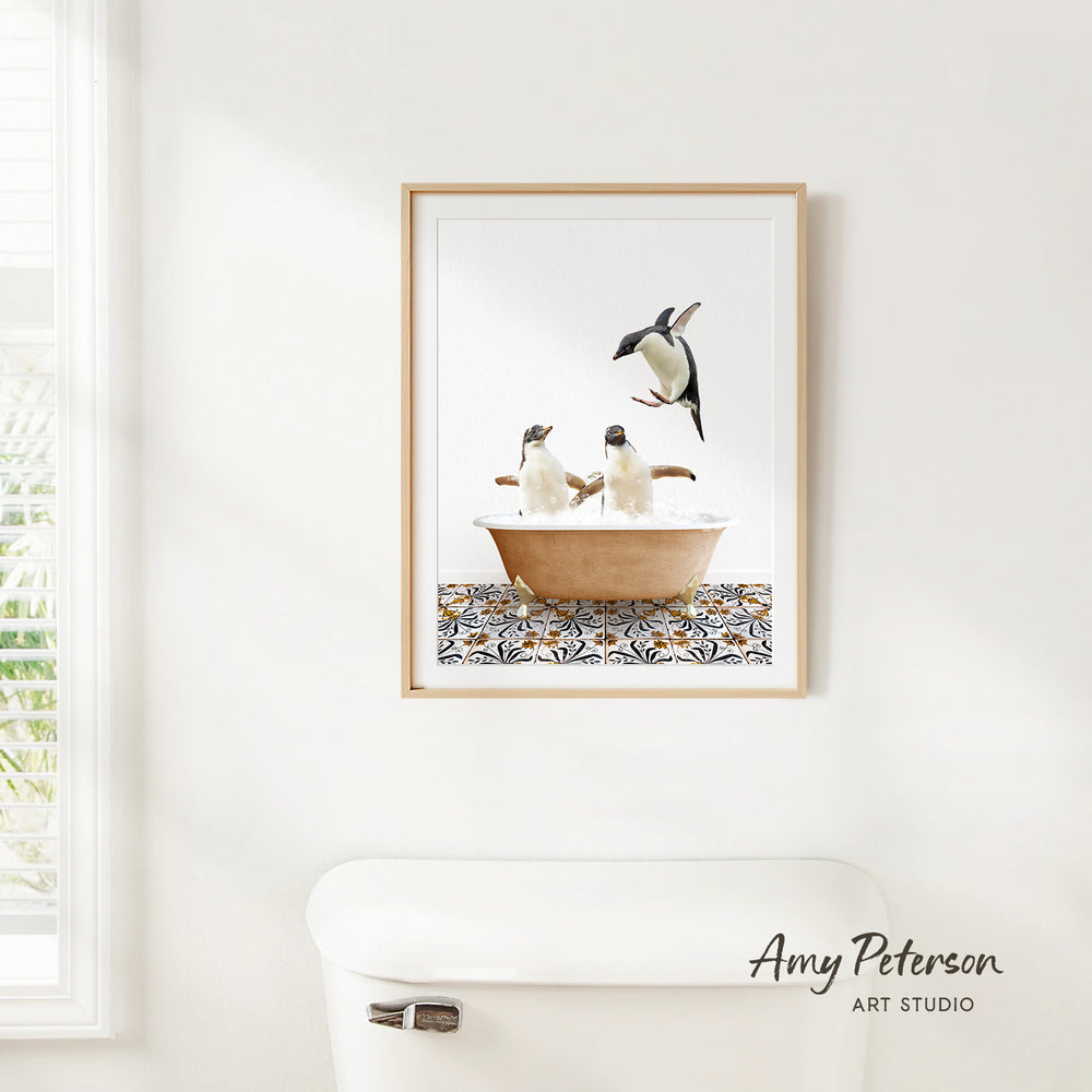 A framed image of two penguins sitting in a bathtub, with one penguin standing on the edge of the tub.