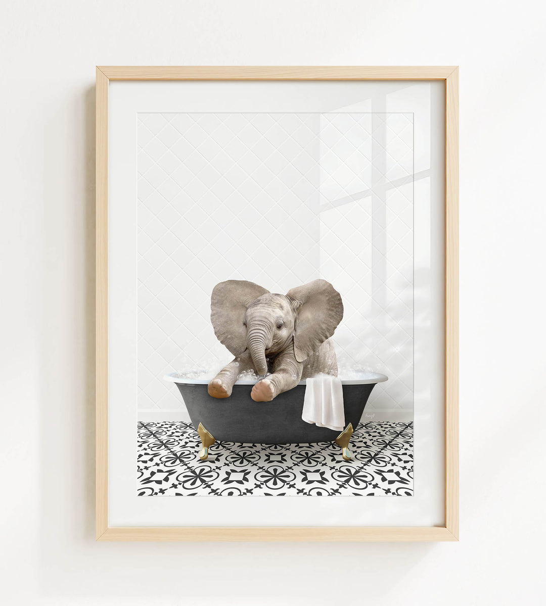 A framed image of a baby elephant sitting in a bathtub filled with water and bubbles.