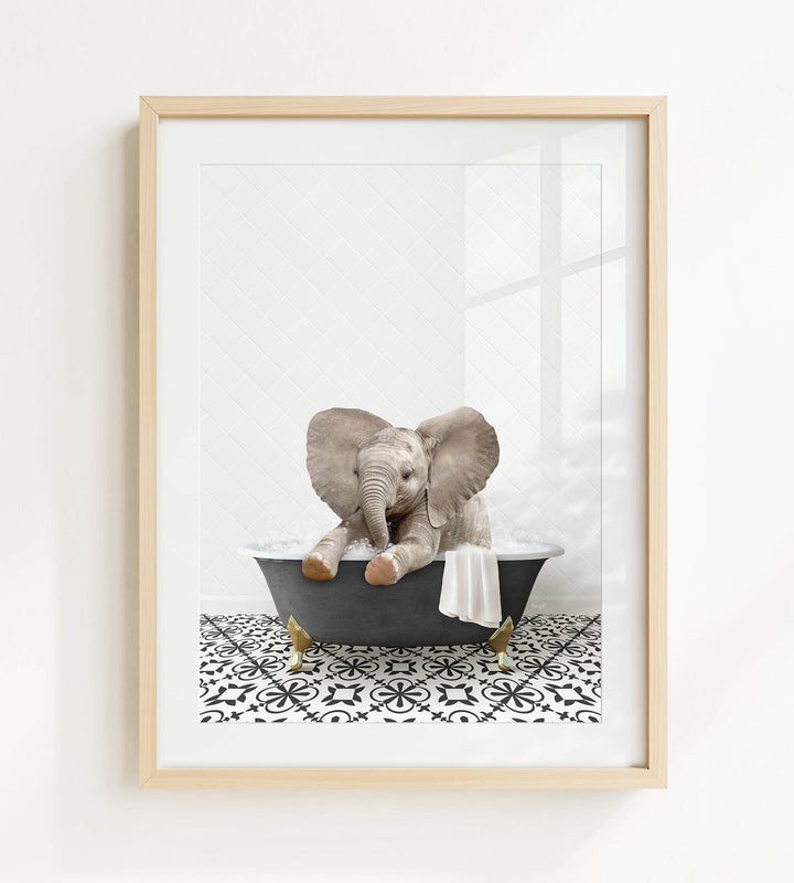 A framed image of a baby elephant sitting in a bathtub filled with water and bubbles.
