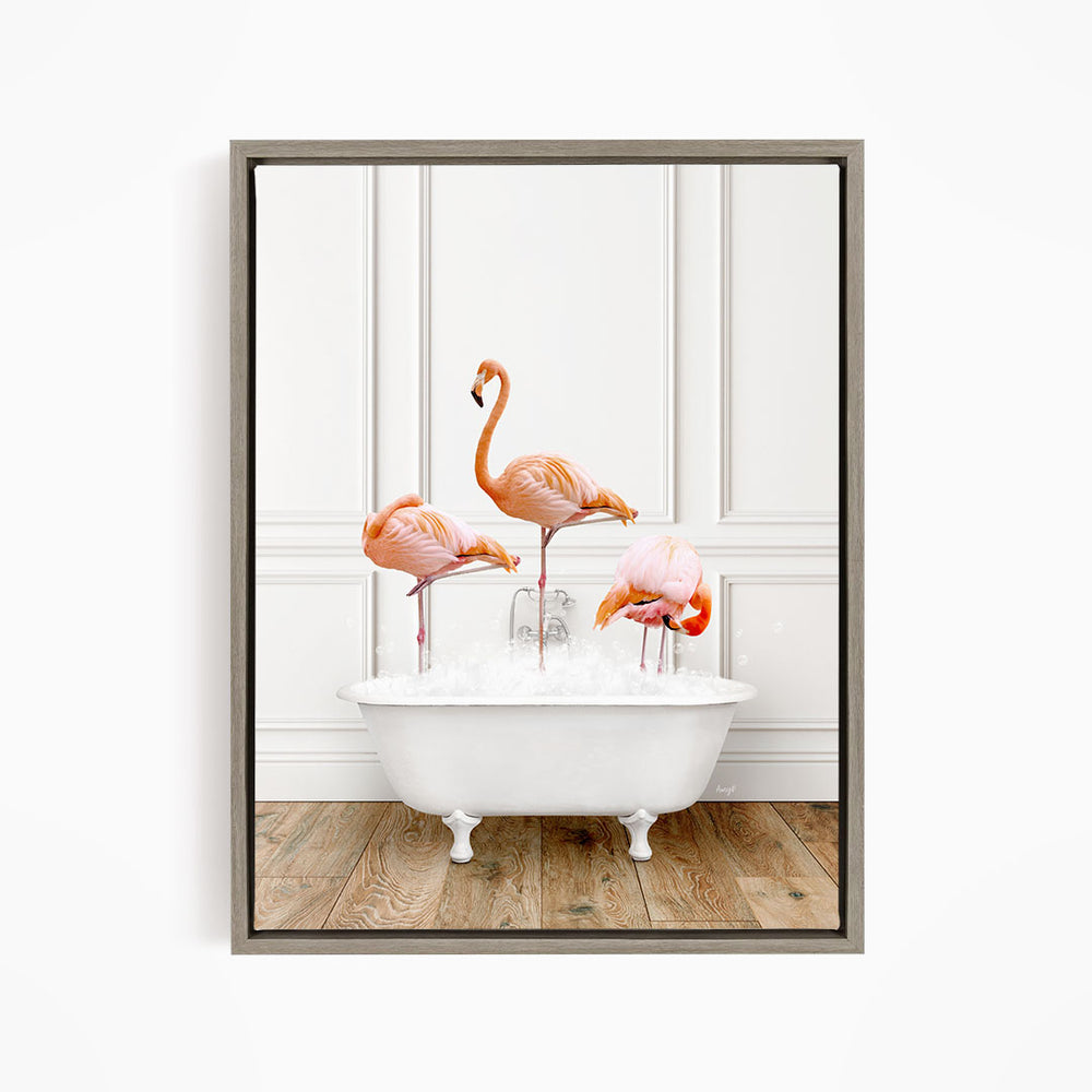 A framed image of three flamingos standing in a white bathtub filled with water.