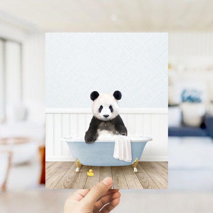 A panda bear sitting in a bathtub filled with bubbles, surrounded by a white bathtub, a towel, and a rubber duck.