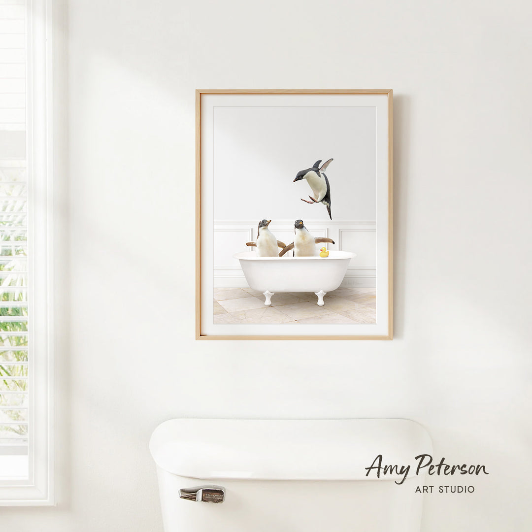 A framed image of two penguins sitting in a bathtub, with one penguin standing on the edge of the tub.