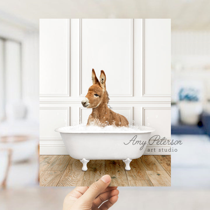 a hand holding a photo of a dog in a bathtub