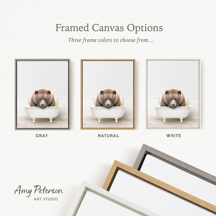 three framed canvas options, each featuring a brown bear sitting in a bathtub. The options include a gray frame, a natural frame, and a white frame.