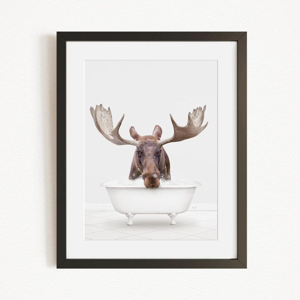 A moose with large antlers is sitting in a white bathtub, appearing to enjoy a relaxing bath.