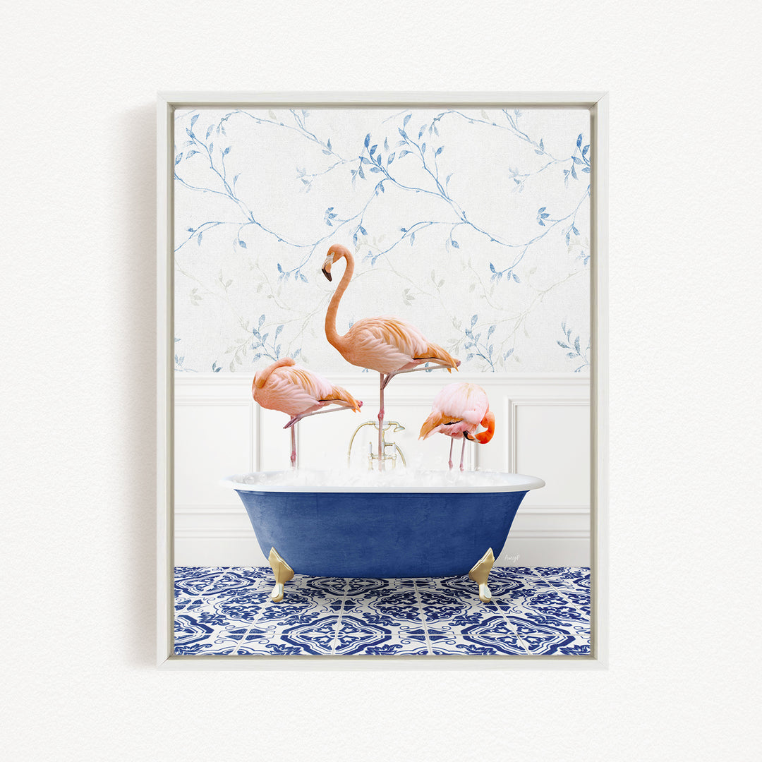 A framed image depicting three flamingos standing in a blue bathtub, with a patterned tile floor and a floral wallpaper in the background.