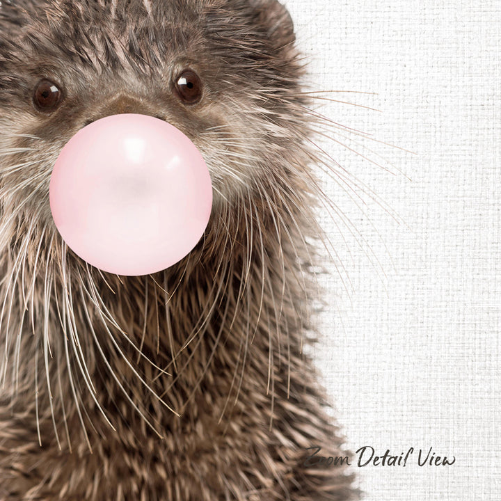 A close-up of an otter blowing a bubble with a pink bubble gum bubble.