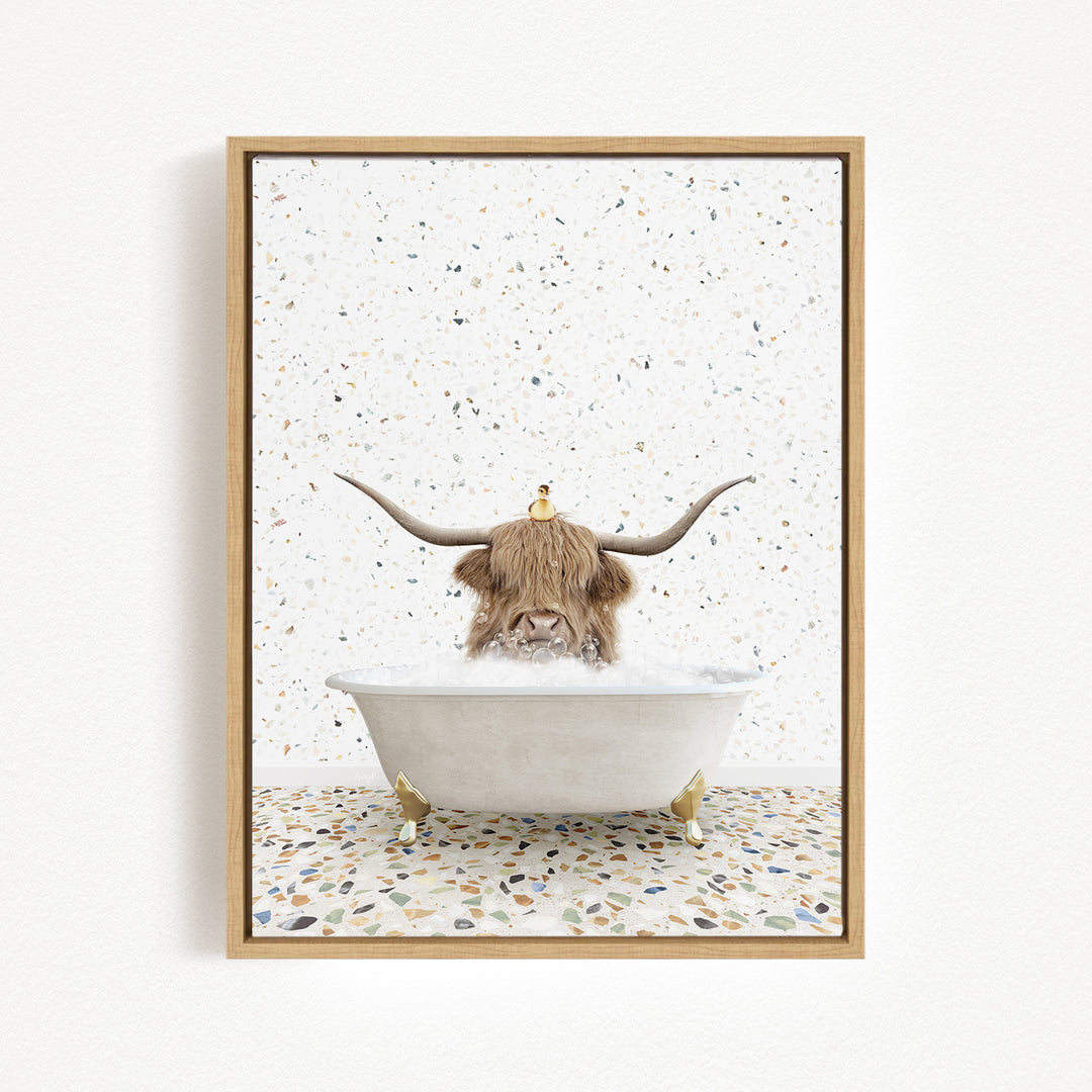 A framed image depicting a cow with long horns sitting in a bathtub filled with water, surrounded by a speckled background.