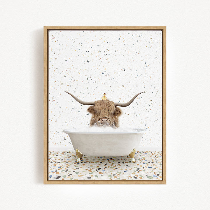 A framed image depicting a cow with long horns sitting in a bathtub filled with water, surrounded by a speckled background.
