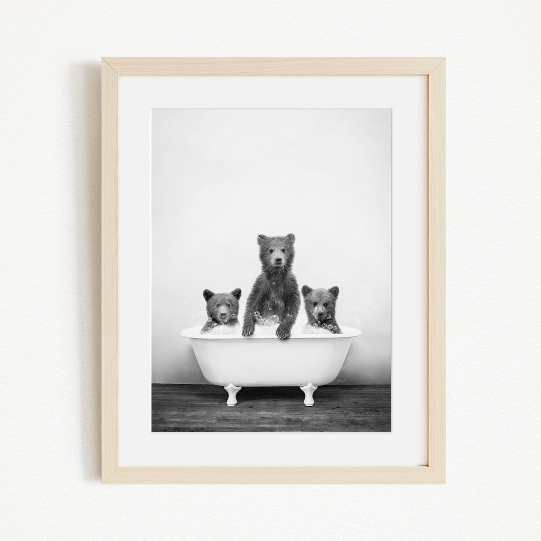 A black and white photograph of three bears sitting in a bathtub, with one bear sitting in the center and the other two bears sitting on either side.