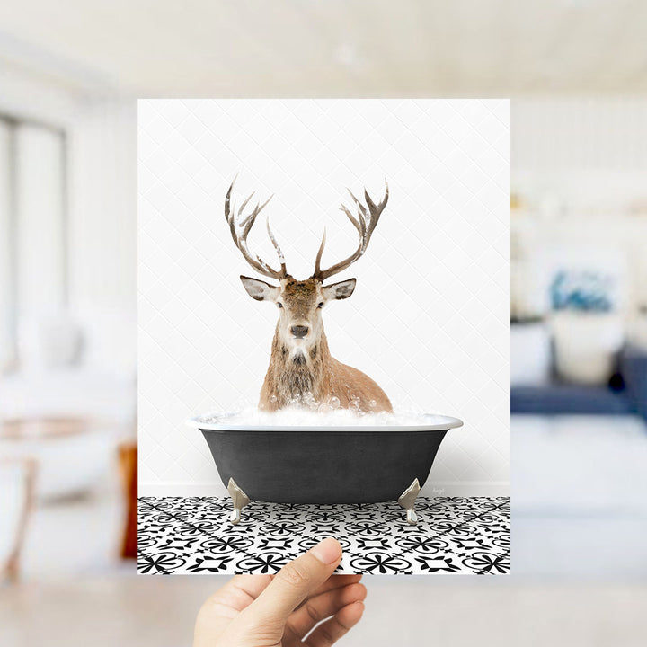 A deer with large antlers is sitting in a bathtub filled with water, creating a whimsical and unexpected scene.