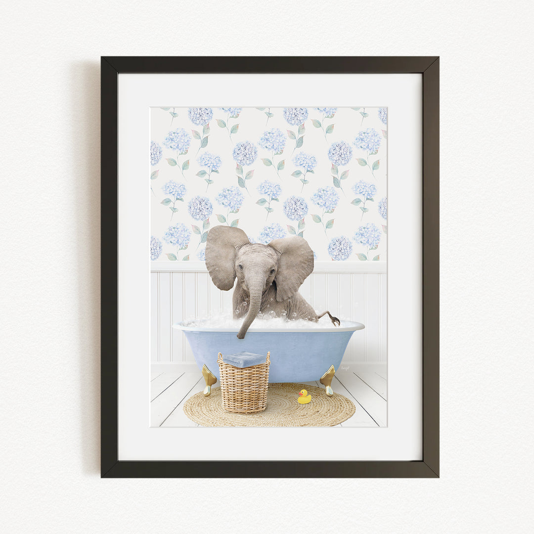 A gray elephant is sitting in a blue bathtub filled with water, surrounded by a wicker basket and yellow rubber ducks.
