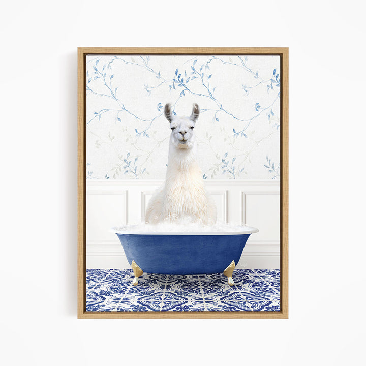 A white llama sitting in a blue bathtub filled with bubbles, with a blue and white floral patterned wall behind it.