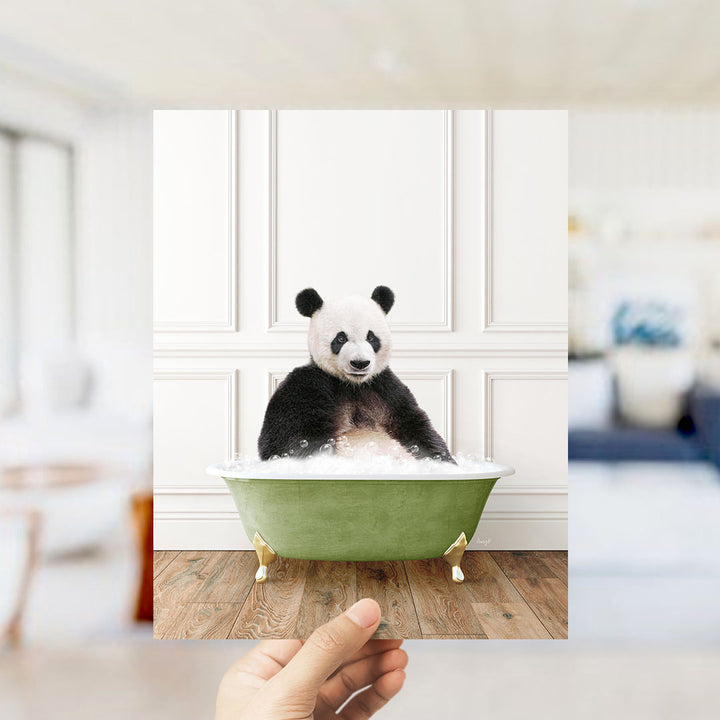 A panda bear sitting in a green bathtub filled with bubbles, with a blurred background suggesting a living room setting.