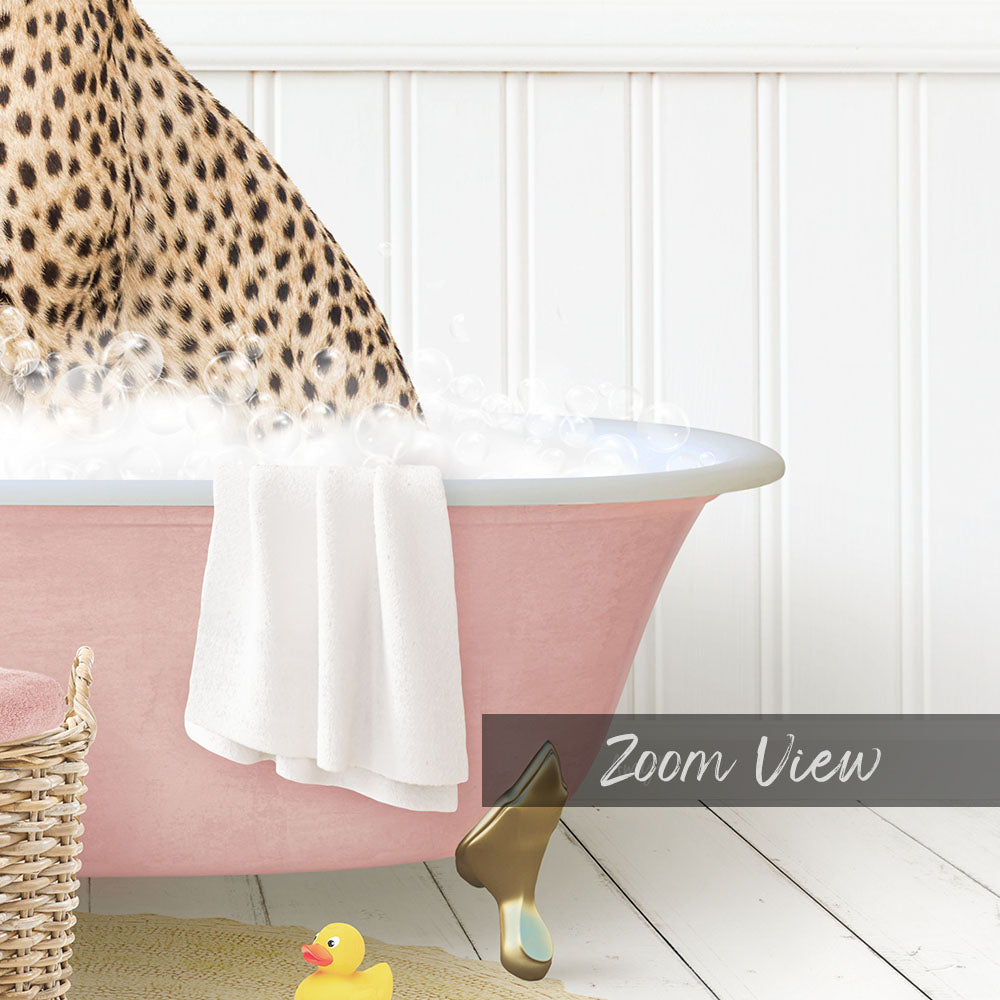 A leopard-print cat is sitting in a pink bathtub filled with water, surrounded by a yellow rubber duck and a white basket.
