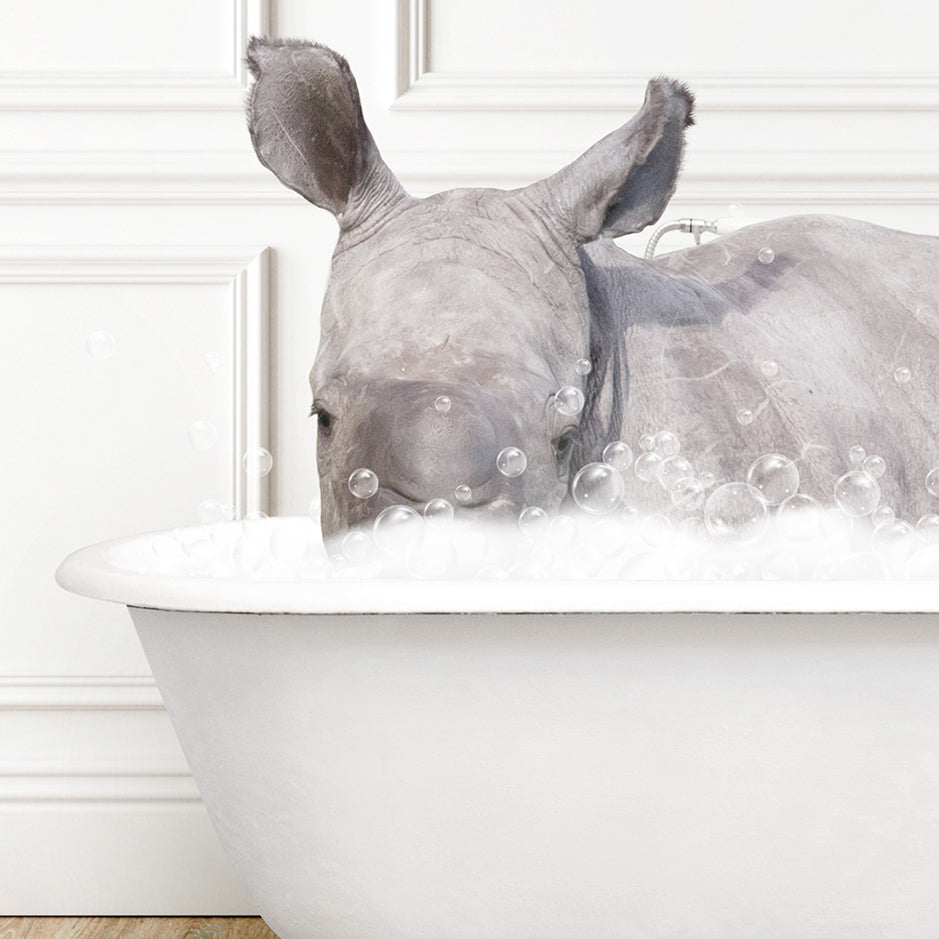 a rhino laying down in a bathtub filled with bubbles