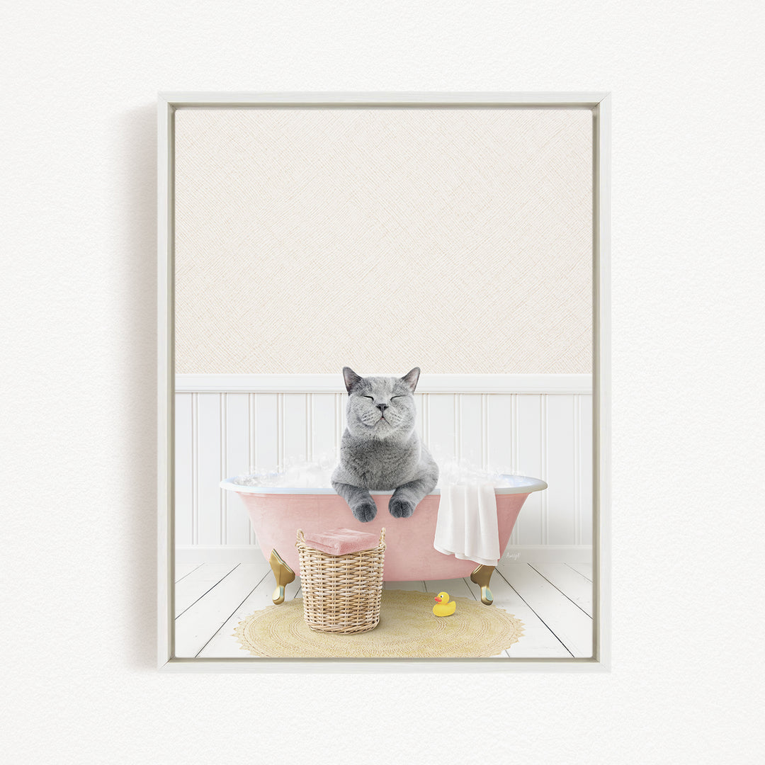 A gray cat sitting in a pink bathtub, surrounded by a yellow rubber duck and a wicker basket.