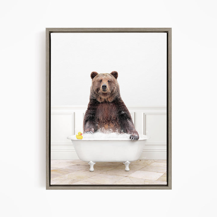 A brown bear sitting in a white bathtub, with a yellow rubber duck floating on the water.