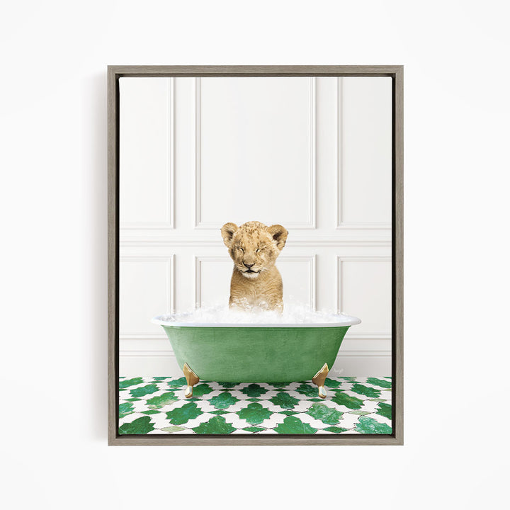 A young lion cub is sitting in a green bathtub filled with water, with its eyes closed and appearing to be enjoying the bath.