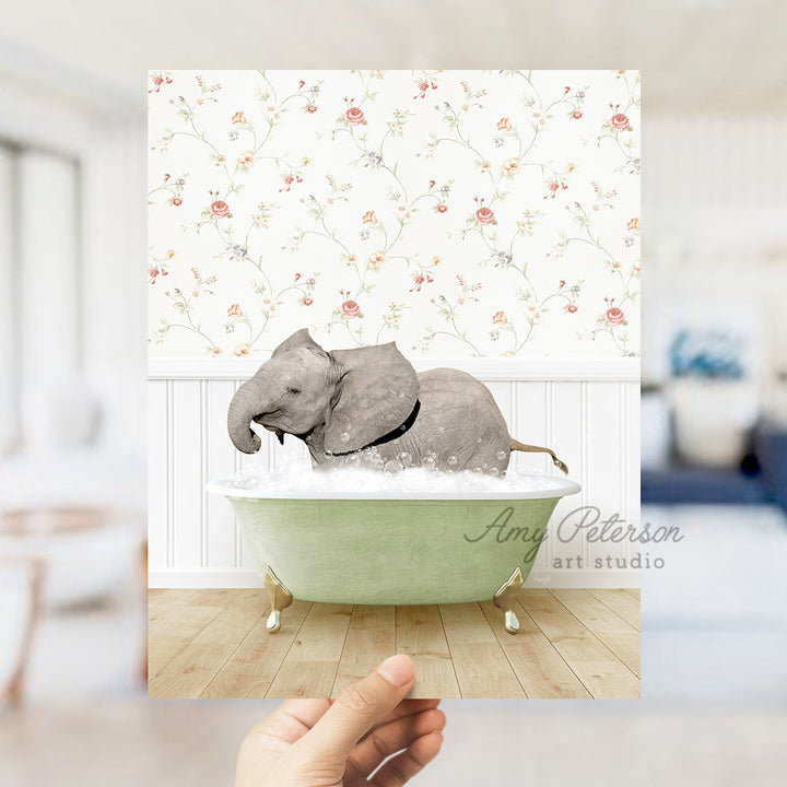 a hand holding up a picture of an elephant in a bathtub