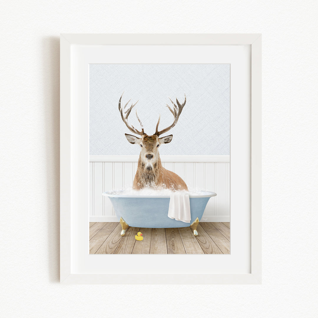 A deer with antlers is sitting in a blue bathtub filled with water, surrounded by yellow rubber duckies.